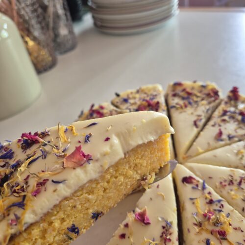 Libanesischer Orangenkuchen mit weißer Schokoladen-Frischkäseglasur und essbaren Blüten im Vanillekind Café